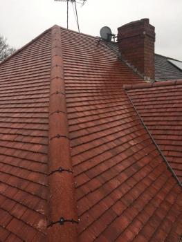 A view from the corner of a property showing a new roof of red tiles. Taken from roof level.