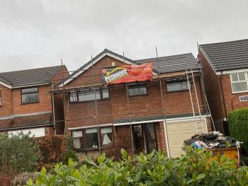 Roofing work done. Pedmore Roofing Services banner on roof